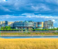 Landtagsgebäude von NRW in Düsseldorf von der anderen Rheinseite aus betrachtet mit dunklen Wolken über dem Gebäude