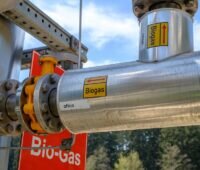 Rohre einer Biogasanlage mit der Aufschrift Biogas, die Ausschreibung für Biomasseanlagen am 1. April 2026 war unterzeichnet.