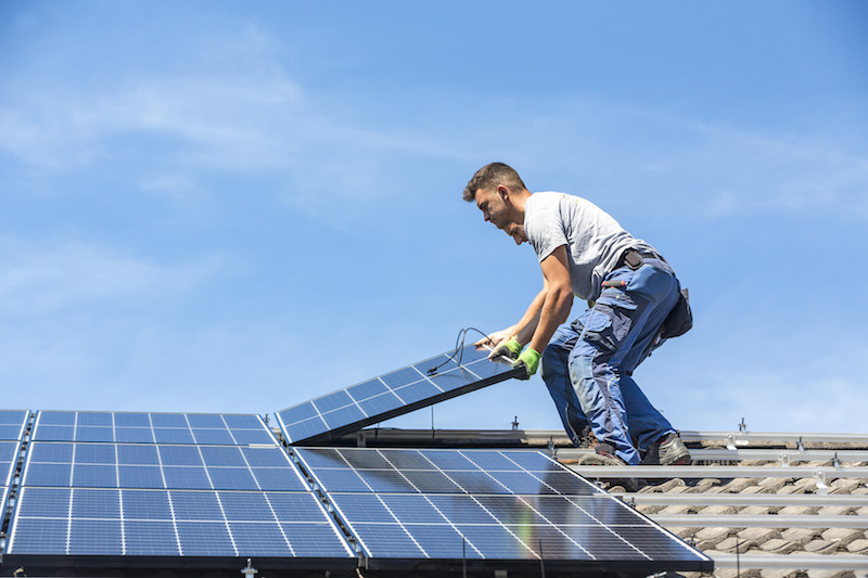 Installateure auf einem Dach montieren oder demontieren PV-Module