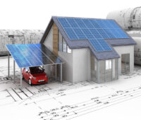Modell eines Hauses mit PV-Modulen auf und vor Architektur-Plänen