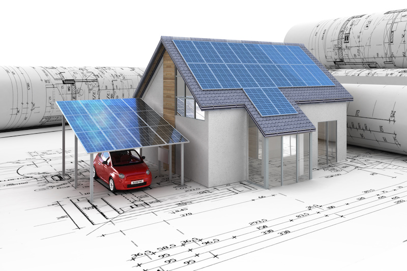 Modell eines Hauses mit PV-Modulen auf und vor Architektur-Plänen