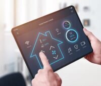 Eine Hand hält ein Tablett mit einer Smart Home App, Rabot Energy macht Geschirrspülmaschinen für dynamischen Stromtarif nutzbar.