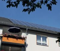 Das Dach eines Mehrparteienhauses, bedeckt mit Photovoltaikmodulen. Ein mögliches Beispiel für ein Mieterstrom-Projekt