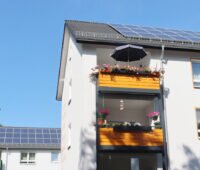 Mehrparteienhäuser mit Photovoltaikanlagen auf dem Dach stehen für eine gemeinschaftliche Gebäudeversorgung / Mieterstrom.