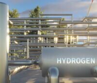 Im Vordergrund Speichertanks für Hydrogen (Wasserstoff), im Hintergrund Röhren sowie dahinter Windkraftanlagen für die Produktion von grünem Wasserstoff.
