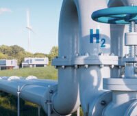 Fotomontage: Pipeline mit der Aufschrift H2 führt durch die Landschaft. Im Hintergrund Wohnhäuser und WIndkraftanlagen.