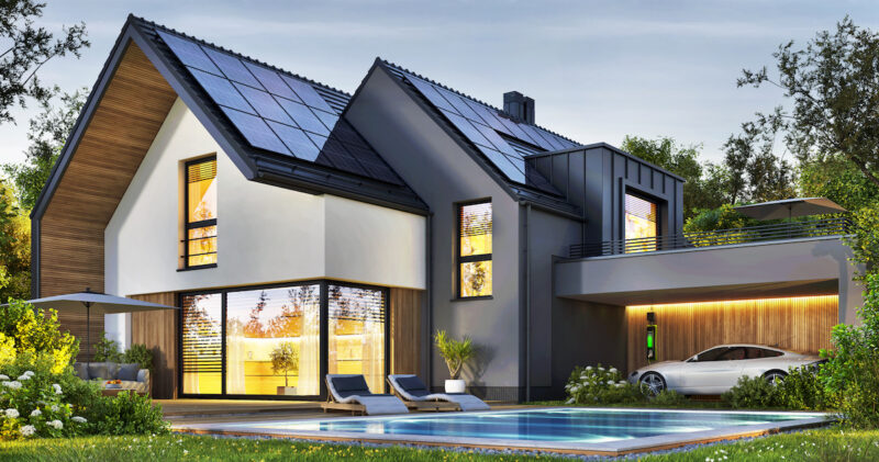 Ein großes Einfamilienhaus mit Solarstromanlage und Elektroauto. Das Ziel des KFW-Programms 442 "Solarstrom für Elektroautos"