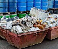 Abfallsammelcontainer, in dem sich alte Batterien stapeln.