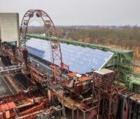 In der Mitte des Bildes eine große PV-Anlage. Sie befindet sich auf einer Industrieanlage der Zeche Zollverein.