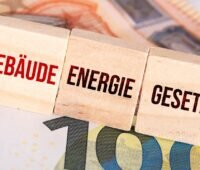 Geldscheine und Holzwürfel mit der Aufschrift Gebäude-Energie-Gesetz, BWP und DEPV wollen GEG und Heizungsförderung beibehalten.
