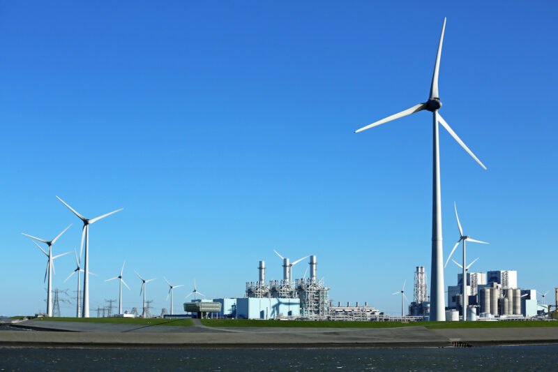 Im Vordergrund und hinten Windkraftanlagen, in der Mitte ein Gaskraftwerk