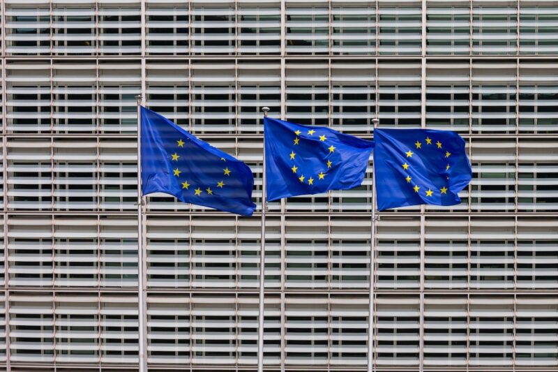 Eine Fassade in Brüssel. Davor Fahnen der Europäischen Union. Der EU-Kommission liegt das Solarpaket zur Prüfung vor, doch sie hat es auf Eis gelegt.