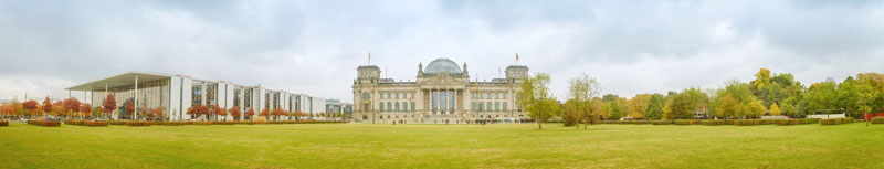 Vorn eine Wiese, hinten in der Mitte das Gebäude des Bundestages