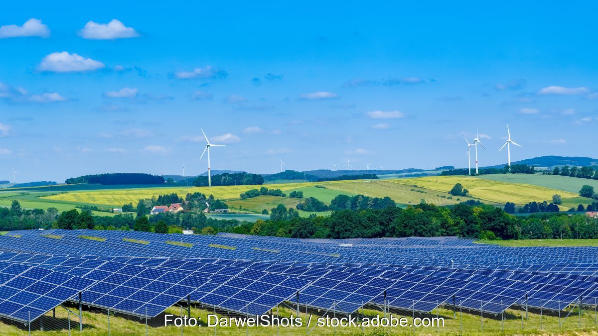 Malerische Landschaft mit Wiesen, Äckern, PV und Windenergie.