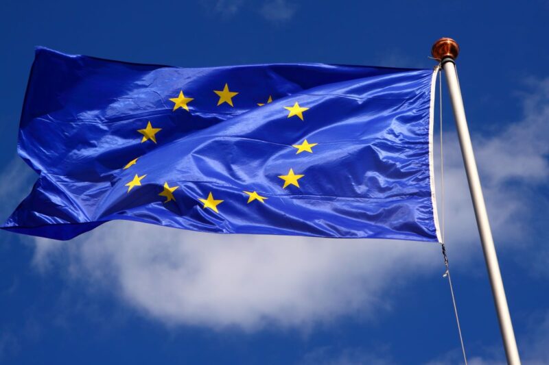 Flagge der EU vor blauem Himmel.