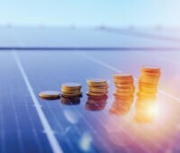 Münzen gestapelt auf einem Photovoltaikmodul