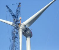 Propeller wird per Kran an eine große Windkraftanlage gehoben