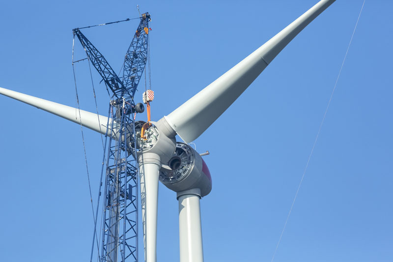 Propeller wird per Kran an eine große Windkraftanlage gehoben