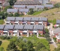 Luftbild zeigt Bestandsquartier mit Reihenhäusern, die alle ein Solardach haben.