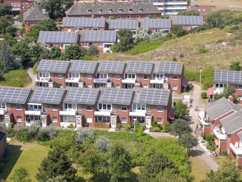 Luftbild zeigt Bestandsquartier mit Reihenhäusern, die alle ein Solardach haben.