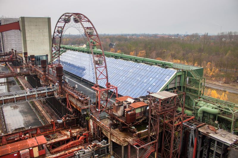 In der Mitte des Bildes eine große PV-Anlage. Sie befindet sich auf einer Industrieanlage der Zeche Zollverein.