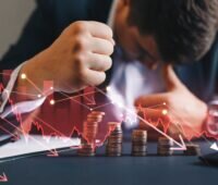 Verzweifelter Geschäftsmann angesichts hinter animierter Grafik mit abnehmenden Münzbeständen und abwärtsgerichteter Kurve.