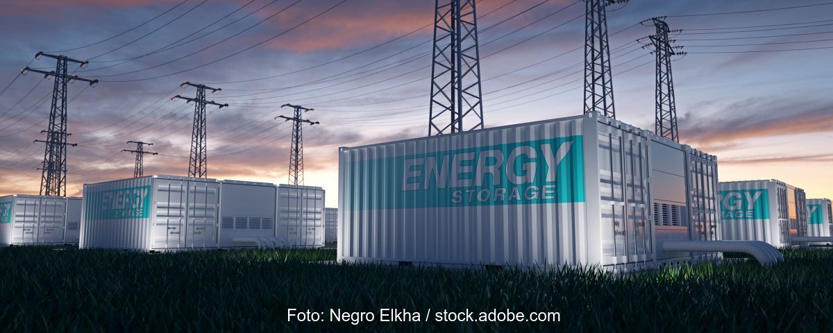Animation zeigt Batteriespeicher mit Strommasten bei Sonnenaufgang unter wolkigem Himmel.