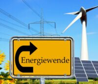 Fotomontage: Ortsschild Energiewende mit Photovoltaik, Windrad , Sonnenblume und Strom-Freileitung