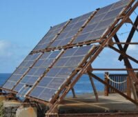 Aufgeständertes PV-Modul am Meer mit korrodiertem Gestell.