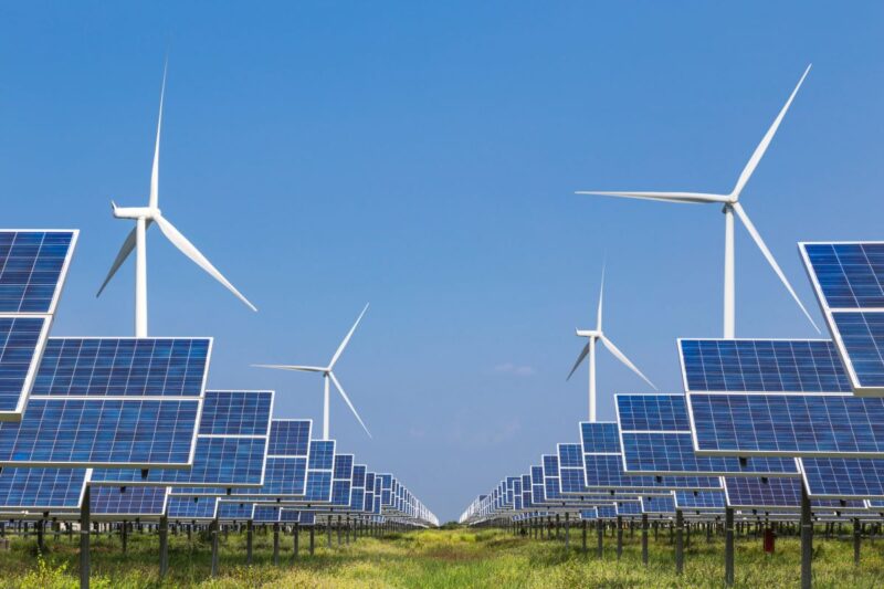 Bis zum Horizont Windanlagen udn Solarmodule unter blauem Himmel.