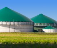 Biogasanlagen hinter einem Feld.