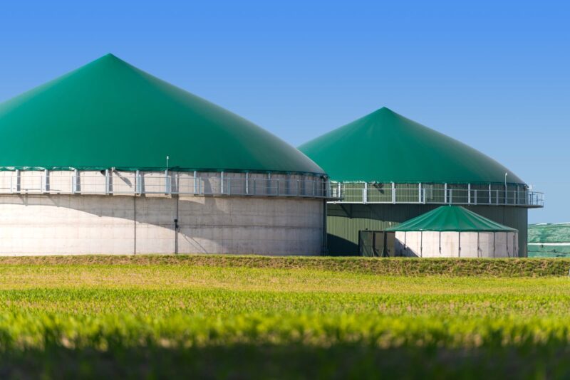 Biogasanlagen hinter einem Feld.