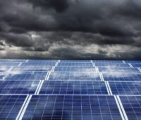 Dunkle Wolken über Solaranlage - Symbolbild für steigende Photovoltaik-Modulpreise im April