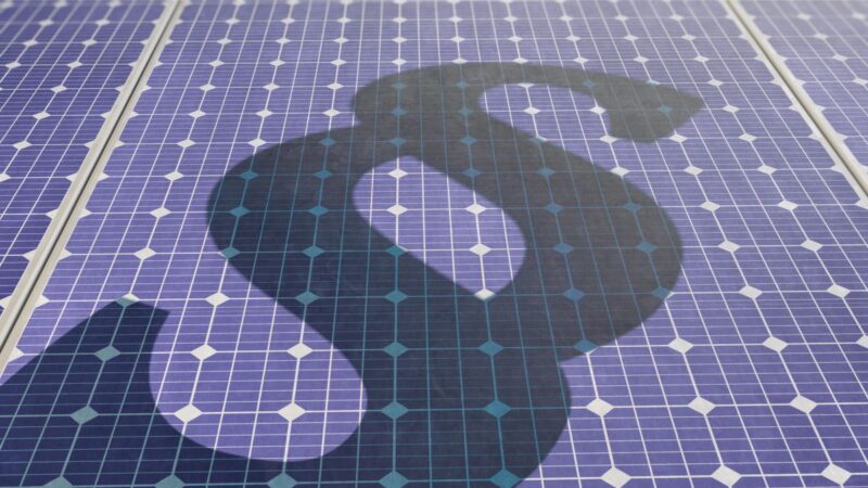 Photovoltaik-Module auf die ein Schatten in Form eines Paragraf-Zeichens fällt.