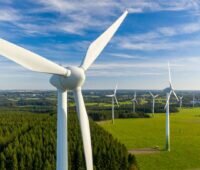 Windpark im Flachland, das Äcker, Wälder und Ortschaften aufweist.
