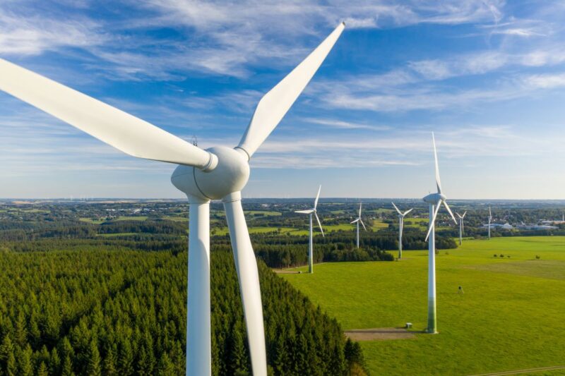 Windpark im Flachland, das Äcker, Wälder und Ortschaften aufweist.