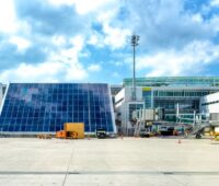 Flughafengebäude mit großflächiger Photovoltaik vom Rollfeld aus.