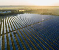 Großer Freiflächen-Solarpark bei tiefstehender Sonne.