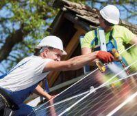 Zwei Männer montieren eine Solaranlage, die geplante Neuordnung der Netzentgelte gefährdet laut BSW-Solar den Ausbau der Photovoltaik.