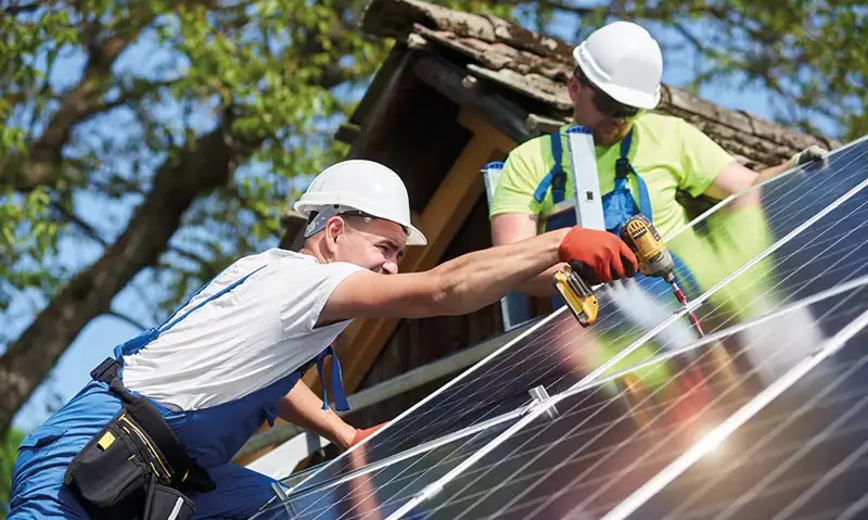 Zwei Männer montieren eine Solaranlage, die geplante Neuordnung der Netzentgelte gefährdet laut BSW-Solar den Ausbau der Photovoltaik.