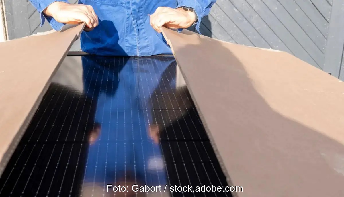 Eine Person öffnet einen Karton mit Photovoltaik-Modulen, Aiko hat eine Betrugswarnung verschickt, die auf unseriöse PV-Modul-Angebote hinweist.