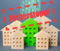 Miniaturhäuser aus Holz mit der Aufschrift Förderstopp, das Bundesministeriums für Wohnen, Stadtentwicklung und Bauwesen hat einen Antragsstopp für das Förderprogramm Energetische Stadtsanierung (KfW 432) verhängt.