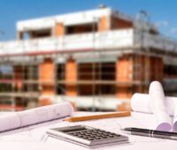 Baupläne ausgebreitet vor einen Neubau, der Bund hat die Effizienzhaus-55-Plus-Förderung aufgestockt.
