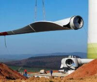 Ein Rotorblatt einer Windenergieanlage hängend an einem Kran, Windenergie-Repowering gewinnt an Bedeutung.