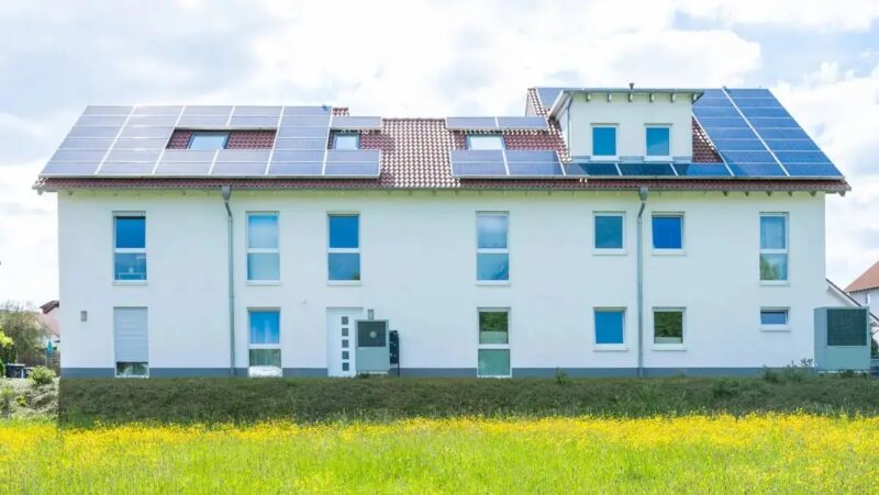 Ein Mehrfamilienhaus mit Photovoltaik-Anlage, das Standortfördergesetz ermöglicht Investitionen von offenen Immobilienfonds in Erneuerbare-Energien-Anlagen.