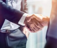 Ein Händedruck zweier Menschen im Anzug, Ecoflow, Anbieter von Stromspeichern und Photovoltaik-Großhändler IBC Solar gehen eine strategische Partnerschaft ein.