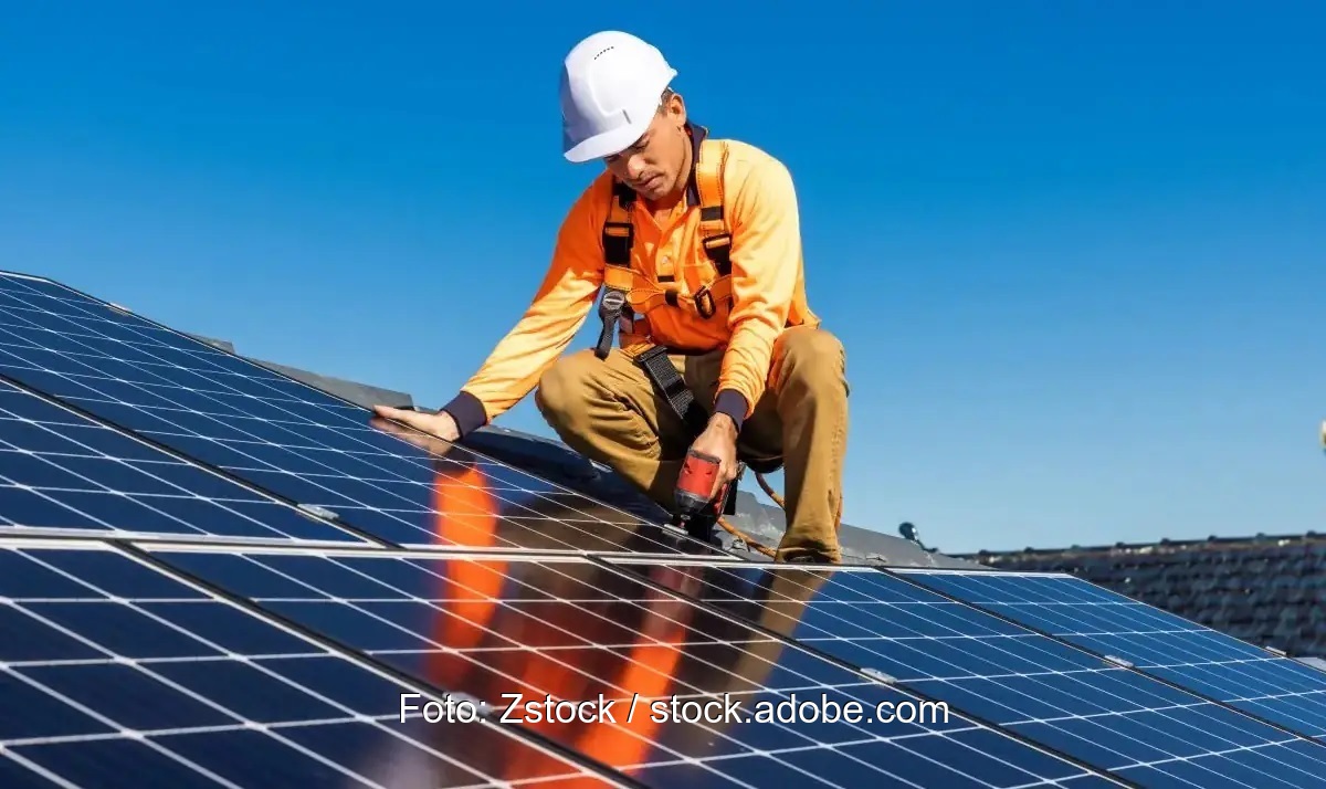 Ein Monteur auf dem Dach baut ein Photovoltaik-Modul ein, Enercity beteiligt sich an Photovoltaik-Installateur Hanovolt.