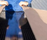 Hände öffnen einen Karton mit Solarmodulen, der deutsche Hersteller Solar Fabrik hat einen hohen Auftragseingang im Februar verzeichnet.