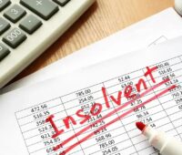 Ein Blatt Papier mit Zahlen und der Aufschrift “insolvent“, Next2Sun beantragt Insolvenzverfahren in Eigenverwaltung.