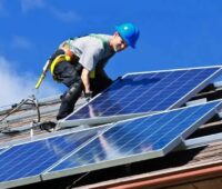 Ein Monteur auf dem Dach installiert ein PV-Modul, die Energie Manufaktur Günzburg GmbH übernimmt den Photovoltaik-Anbieter Sungrade.